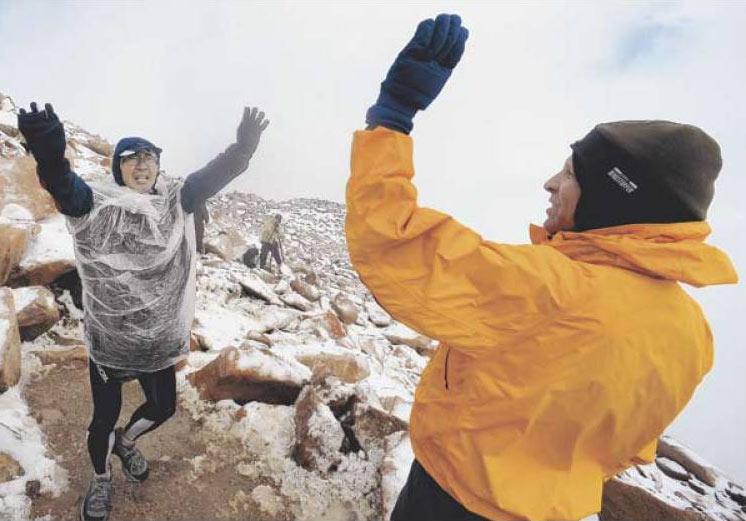 Kenichiro Maemura, left, of Novi, Mich., got congratulated by Mike Sandil as he was one of the last to reach the summit of Pikes Peak.